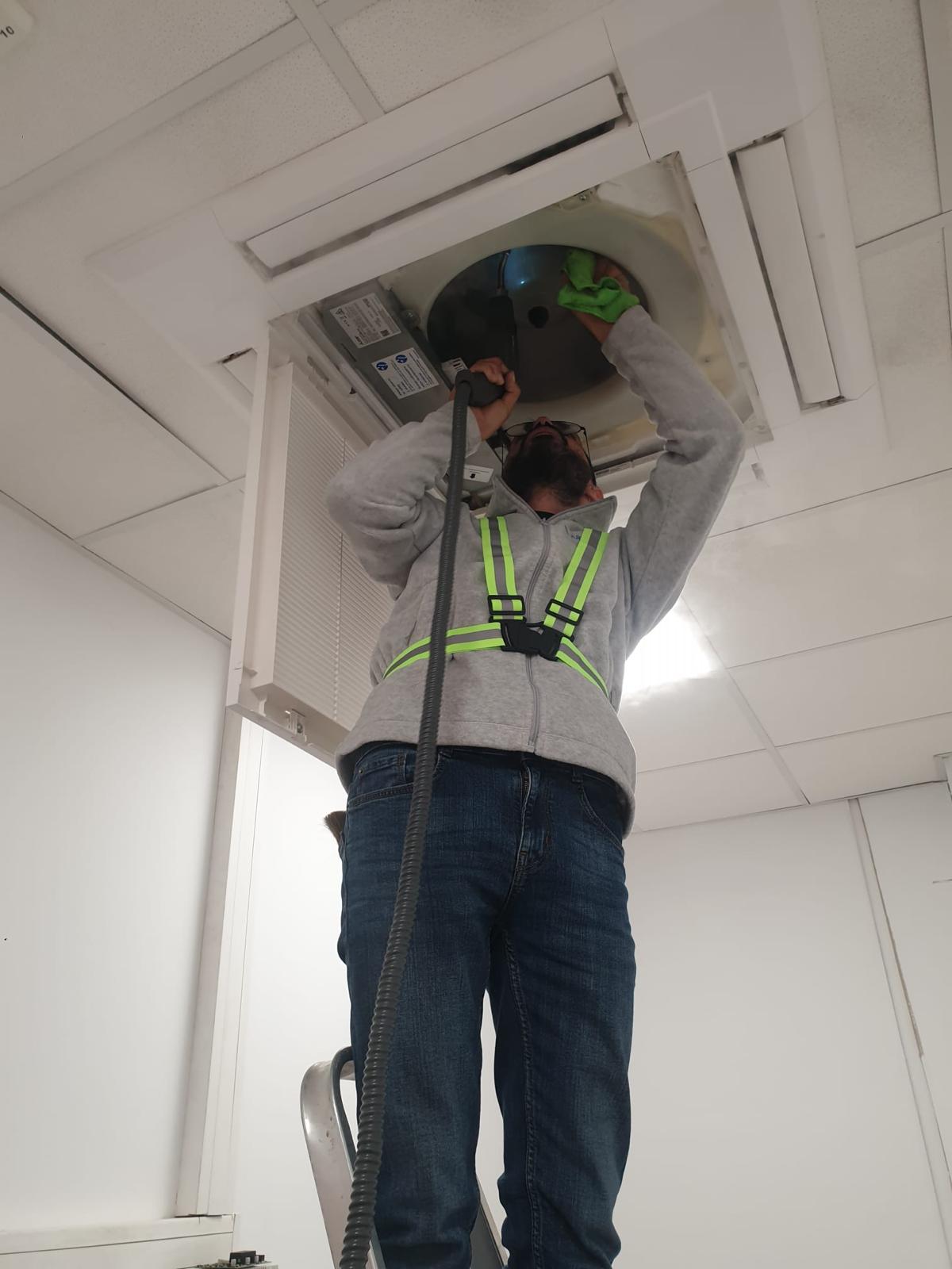 Tehnician efectuând întreținerea unei casete de plafon