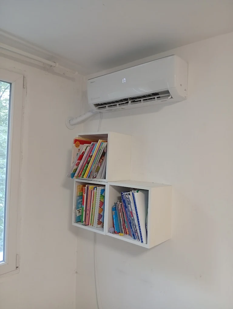 Unitate interioară de aer condiționat montată deasupra unei biblioteci