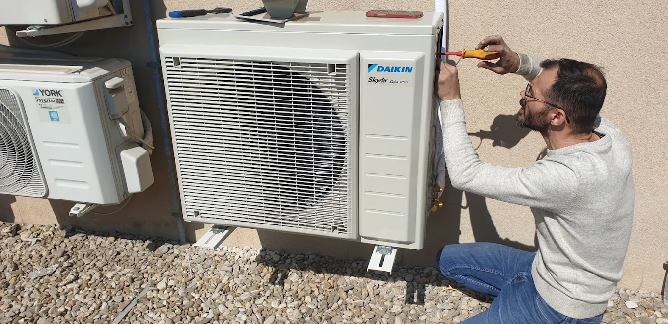 Tehnician lucrând la conexiunile unei unități exterioare Daikin