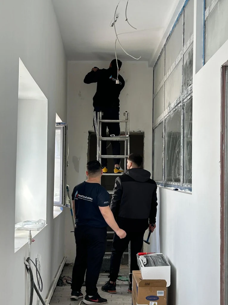 Echipa EcoClimaTech montând o unitate interioară într-un hol