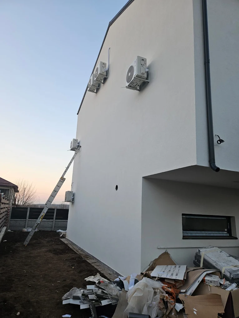 Mai multe unități exterioare de aer condiționat montate pe fațada unei clădiri